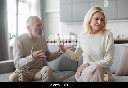 Couple having a serious disagreement in their living room during daytime Stock Photo