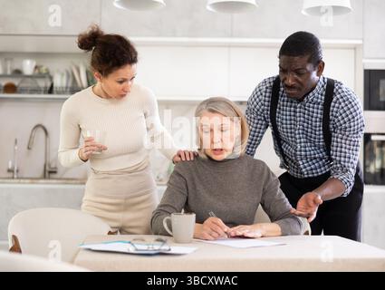 Couple discussing testament with elderly woman Stock Photo