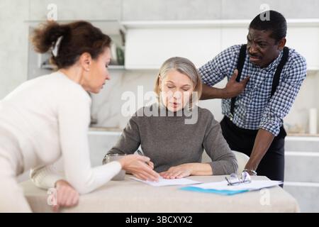 Couple discussing testament with elderly woman Stock Photo