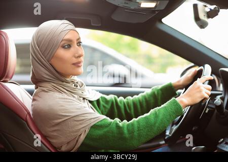 Cheerful muslim woman driving her new car Stock Photo