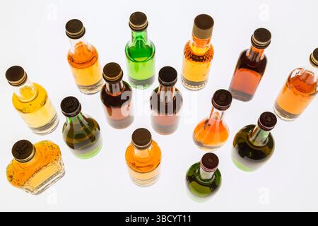 Colourful assorted shaped miniature size liquor bottles on white translucent background. Stock Photo