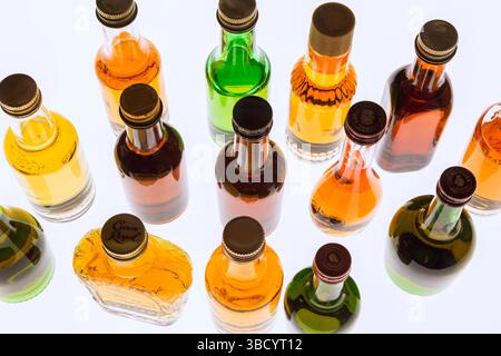 Colourful assorted shaped miniature size liquor bottles on white translucent background. Stock Photo