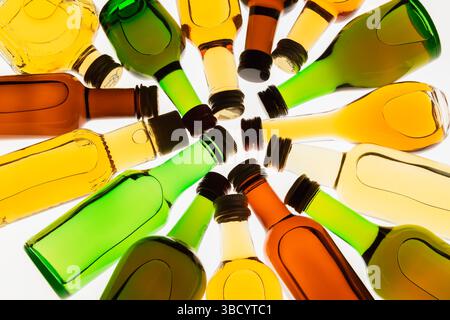 Colourful assorted shaped miniature size liquor bottles laid flat in circular design on white translucent background. Stock Photo
