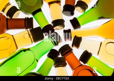 Colourful assorted shaped miniature size liquor bottles laid flat in circular design on white translucent background. Stock Photo