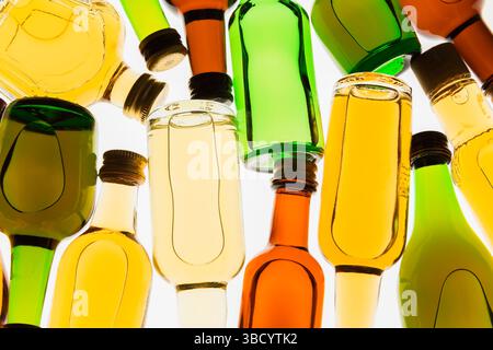 Colourful assorted shaped miniature size liquor bottles laid flat on white translucent background. Stock Photo