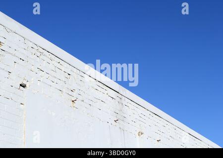 Close-up of a white brick building wall against a clear blue sky background abstract Stock Photo