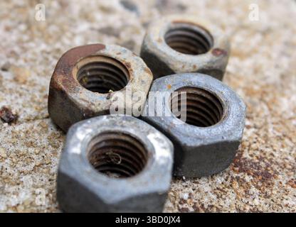 Close up of rusty metal nuts on a cement background Stock Photo