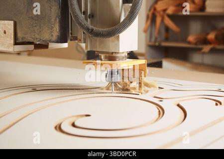 Numerically controlled woodworking machine cuts rounded complex lines on the canvas. Computer numerical control. CNC. Stock Photo