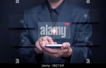 Watching online video is now embedded in everyday life. A man watches a video, live streaming, from his smartphone for entertainment, including stream Stock Photo
