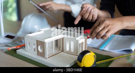 Eco-Friendly Engineering. Engineers collaborating on sustainable building model. Stock Photo