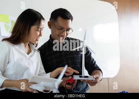 Sustainability and Engineering. Engineers collaborating on wind energy models in a modern office. Stock Photo