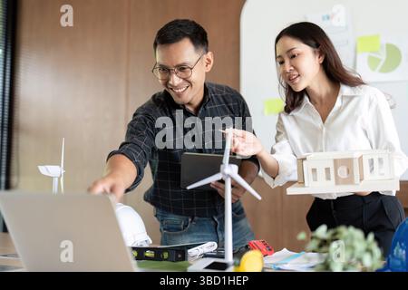 Sustainability and Engineering. Engineers collaborating on eco-friendly project plans in a workspace. Stock Photo