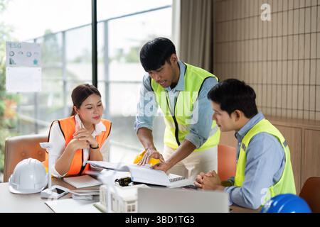 Green Tech Strategy Meeting. Engineers collaborating on sustainable projects in an eco-friendly workspace. Stock Photo