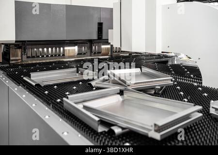 Automatic metal sheet bending machine at work in factory. CNC Panel Bender (Press Arm Type) Stock Photo