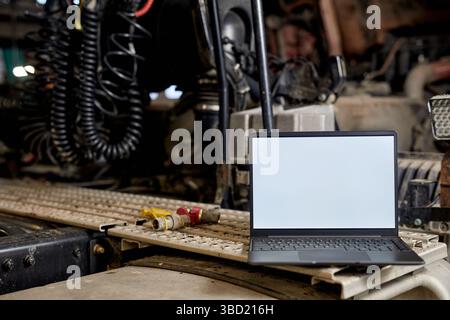 Open Laptop Displaying Blank Screen on Industrial Workbench Stock Photo