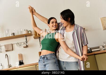 Couple enjoys a delightful dance in their cozy kitchen, celebrating their love and connection. Stock Photo
