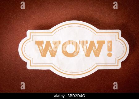 Wow Expression Label on Brown Background Representing Surprise or Excitement. Stock Photo