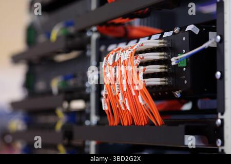 Closeup of industrial managed modular gigabit ethernet switch with connected fiber optic cables. Selective focus. Stock Photo