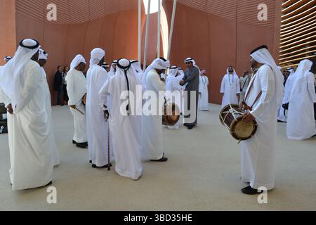 Expo Milano 2015. UAE pavilion view with sand dunes imitation and desert style walls. Group of men dancers with drums and white traditional dresses. Stock Photo