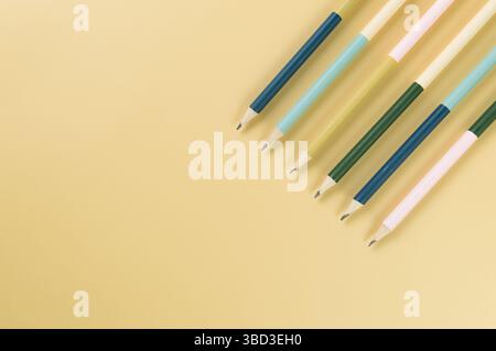 Top view of colorful pencils on yellow background. School, office, art wallpaper. Flat lay, copy space. Stock Photo