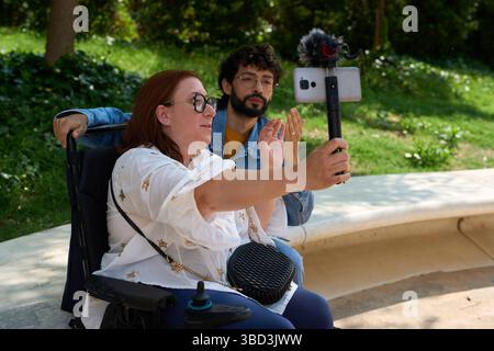Content creators with disability recording video in park - wheelchair and disability concept Stock Photo
