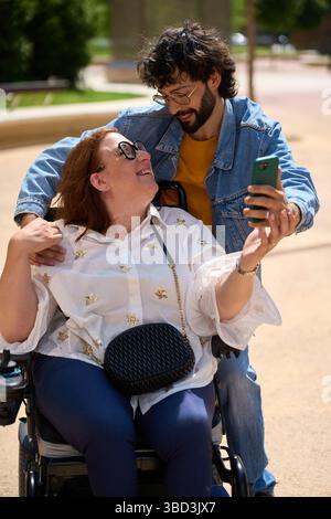 Woman in a wheelchair at the park with her boyfriend Stock Photo - Alamy