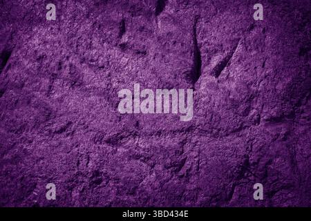 Dark, textured stone wall with purple highlights Stock Photo
