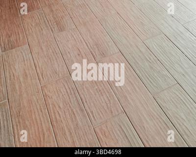 Light brown tiles arranged in a staggered pattern, creating a modern and stylish floor surface Stock Photo