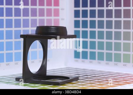 Magnifier or printer's loupe sits on a cyan test sheet in a pre-press ...