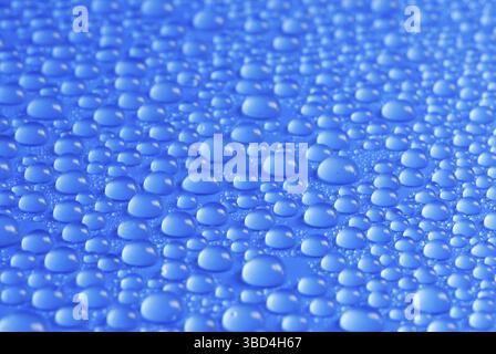 Many small blue drops of water on a blue surface Stock Photo