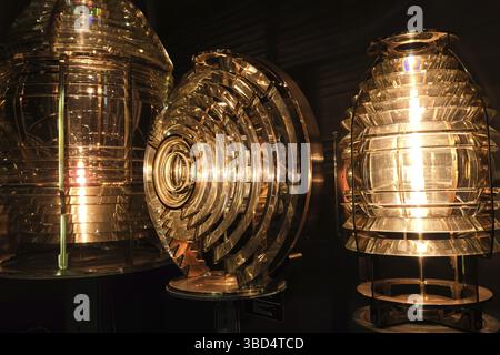 Close image of the glass prisms making up Fresnel lens with lights on. Used in lighthouse beacons and lanterns to concentrate light from compact lamp Stock Photo