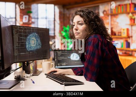 System administrator working in AI tech agency providing custom software development services. IT staff member using artificial intelligence technology to streamline coding process in startup office Stock Photo