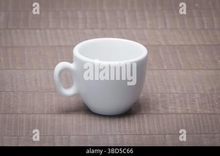 Clean and empty ceramic cup for espresso without saucer on wooden table Stock Photo