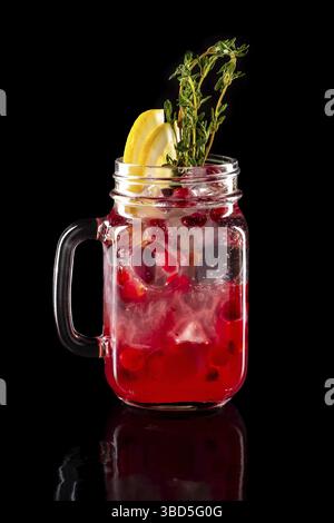 Cold fruit lemonade in mason jar isolated on black background Stock Photo