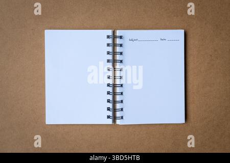 Open white journal notebook, top view. Isolated on brown cardboard surface. Stock Photo