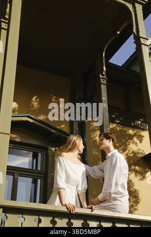 Young couple in love standing on balcony and looking at each other Stock Photo