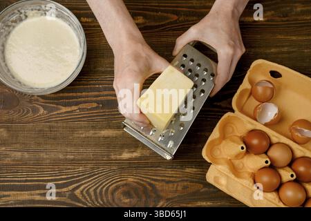 Male hands using grater for cheese, top view Stock Photo