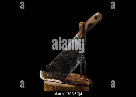 Rustic butcher meat knife, cleaver and fork on black background Stock Photo