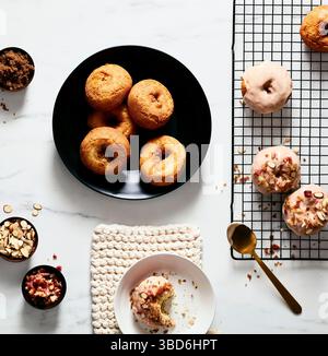 Plain and glazed donuts styled with toppings on white surface Stock Photo