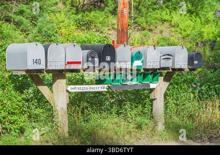 Row of mailboxes of different sizes at the roadside in rural Maine, New England, USA Stock Photo
