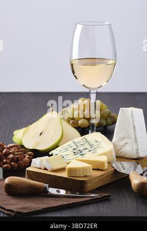 Snack for wine, sheese plate and fruits on dark wooden table Stock Photo