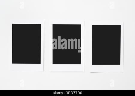 Three blank polaroid photo papers on a white background. Mockup, template, or copy space. Instant camera photo print frame Stock Photo