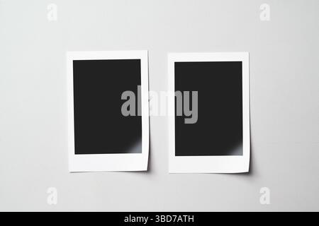 Two blank polaroid photo papers on a white background. Mockup, template, or copy space. Instant camera photo print frame Stock Photo