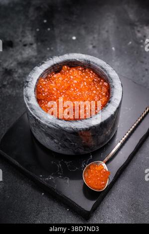 Exquisite salmon roe, vibrant and rich, ideal for adding a touch of elegance to your culinary creations. black background. top view. Stock Photo