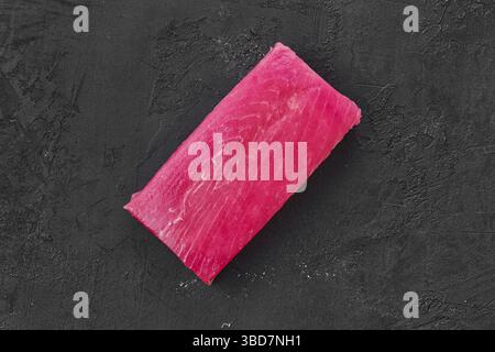 Raw frozen tuna fillet on black background Stock Photo