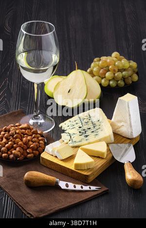 Snack for wine, sheese plate and fruits on dark wooden table Stock Photo