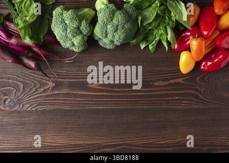 Fresh vegetables on dark wooden background, beetroot, broccoli, basil and bell pepper Stock Photo