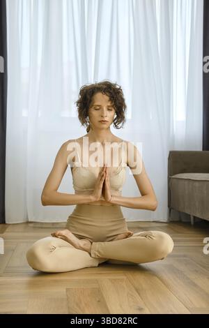 Meditative woman sits in lotus position at home Stock Photo