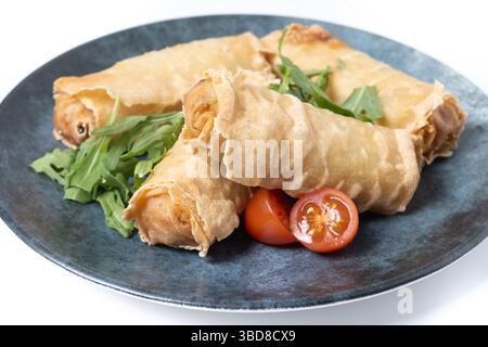 Crispy Spring Rolls on Ceramic Plate isolated on white background Stock Photo