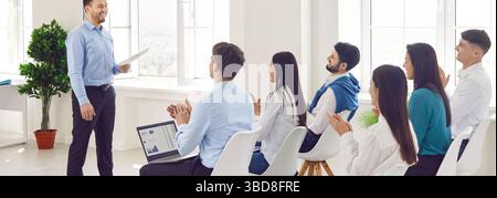 Business coach giving presentation for new company staff, group of professionals gathered Stock Photo